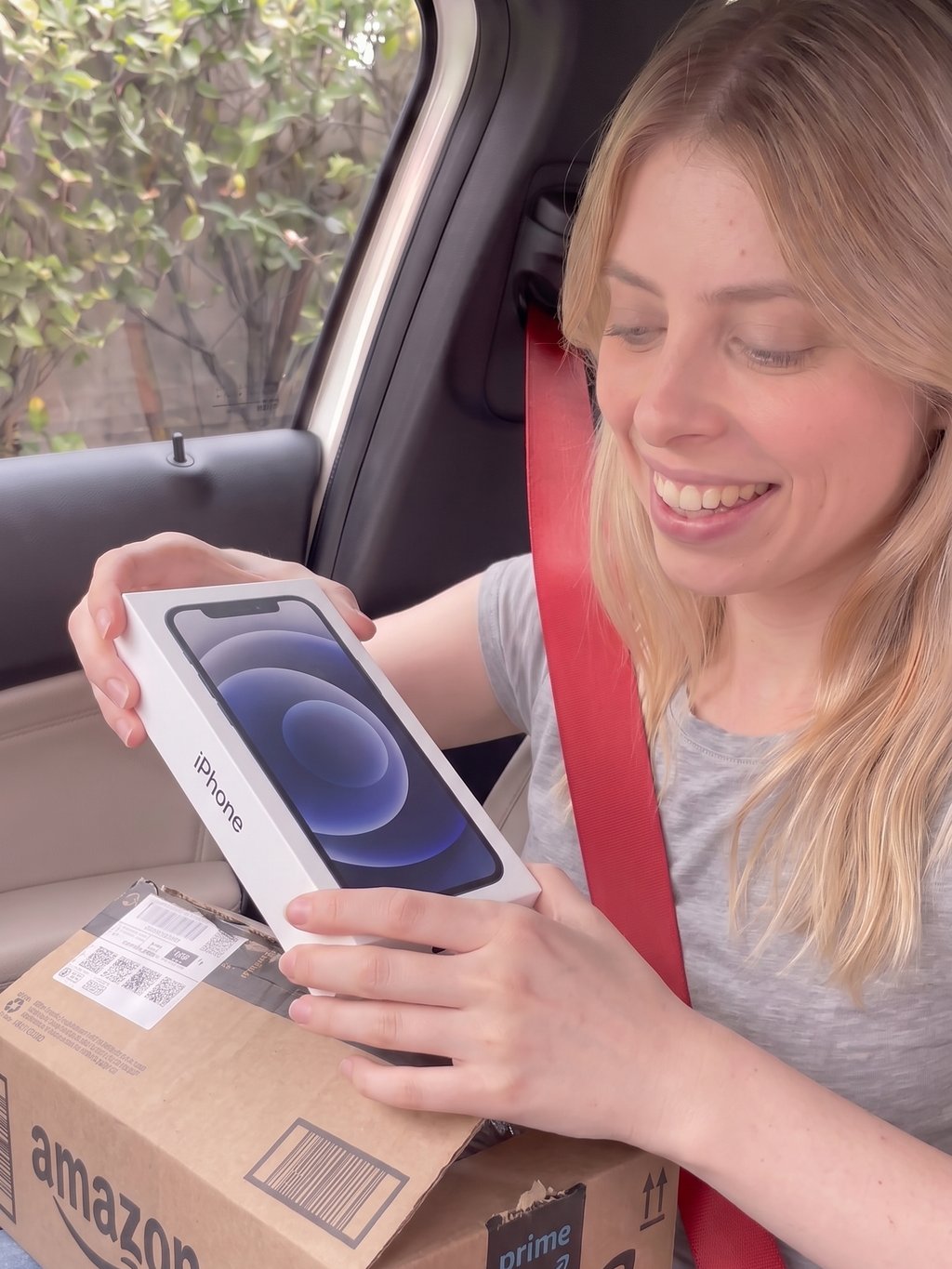 Cliente dentro do carro mostrando o celular lacrado que veio na caixa