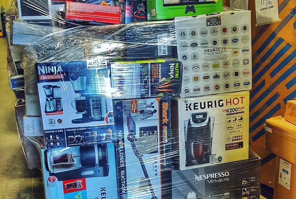 Palete carregado de caixas de eletrodomésticos e eletrônicos de marca, envelopado em plástico